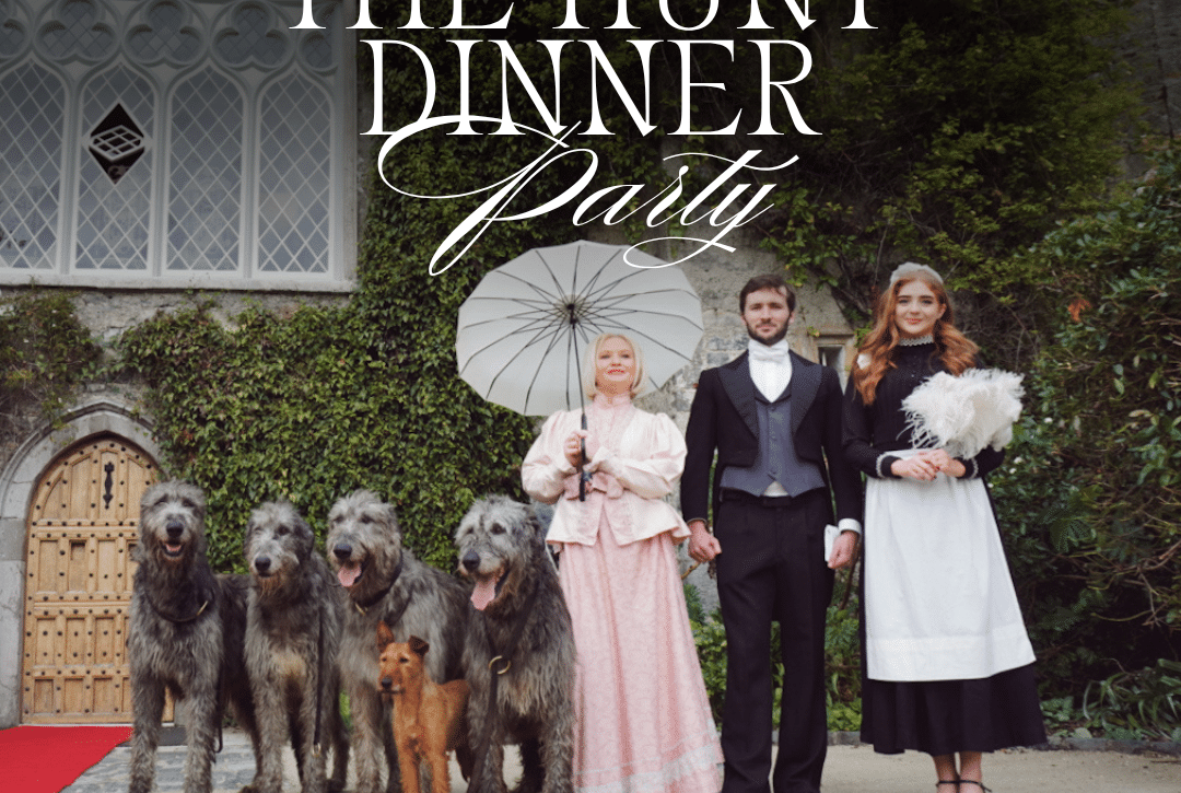 Three people in period costumes stand outside a large building with four large dogs and one smaller dog. One person holds a parasol. Text reads: "The Hunt Dinner Party at Malahide Castle. Every Saturday from 9th of May (Except concert nights).