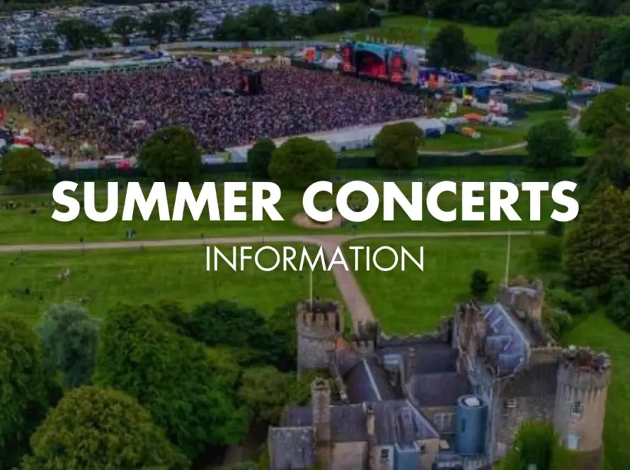 Aerial view of a large outdoor concert crowd near a stage, surrounded by green fields and trees, with Malahide Castle in the foreground. Text reads: "Summer Concerts Information''