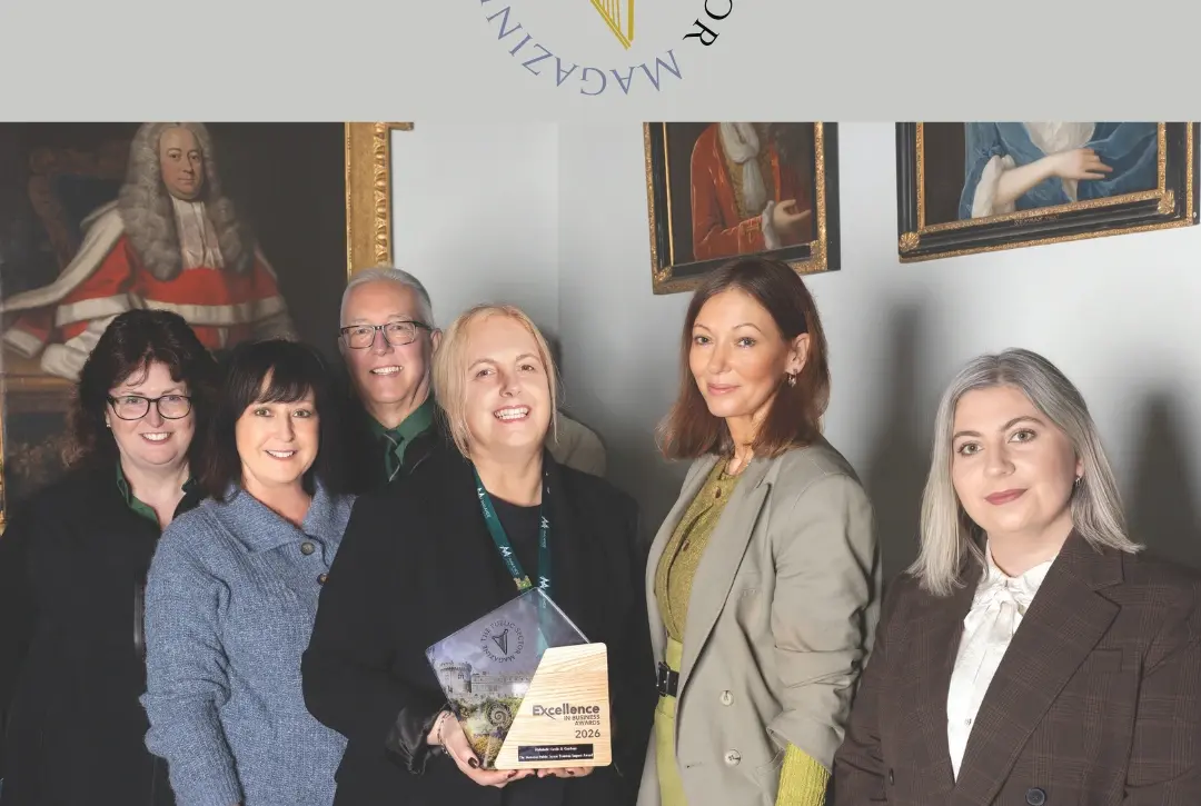 6 people standing together posing for a group photo smiling inside the castle holding an award.