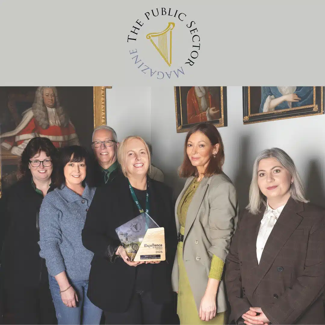 6 people standing together posing for a group photo smiling inside the castle holding an award.