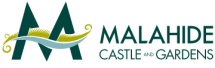 Logo for Malahide Castle and Gardens featuring two large, stylized dark green "M"s with a yellow and white decorative element resembling a medieval banner draped across them. The text "Malahide Castle and Gardens" is in dark green to the right of the emblem.